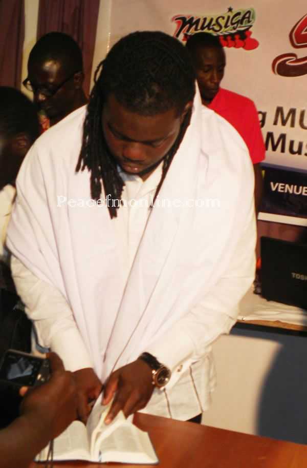 Obour looking for a Bible quotation before his speech   - Obour